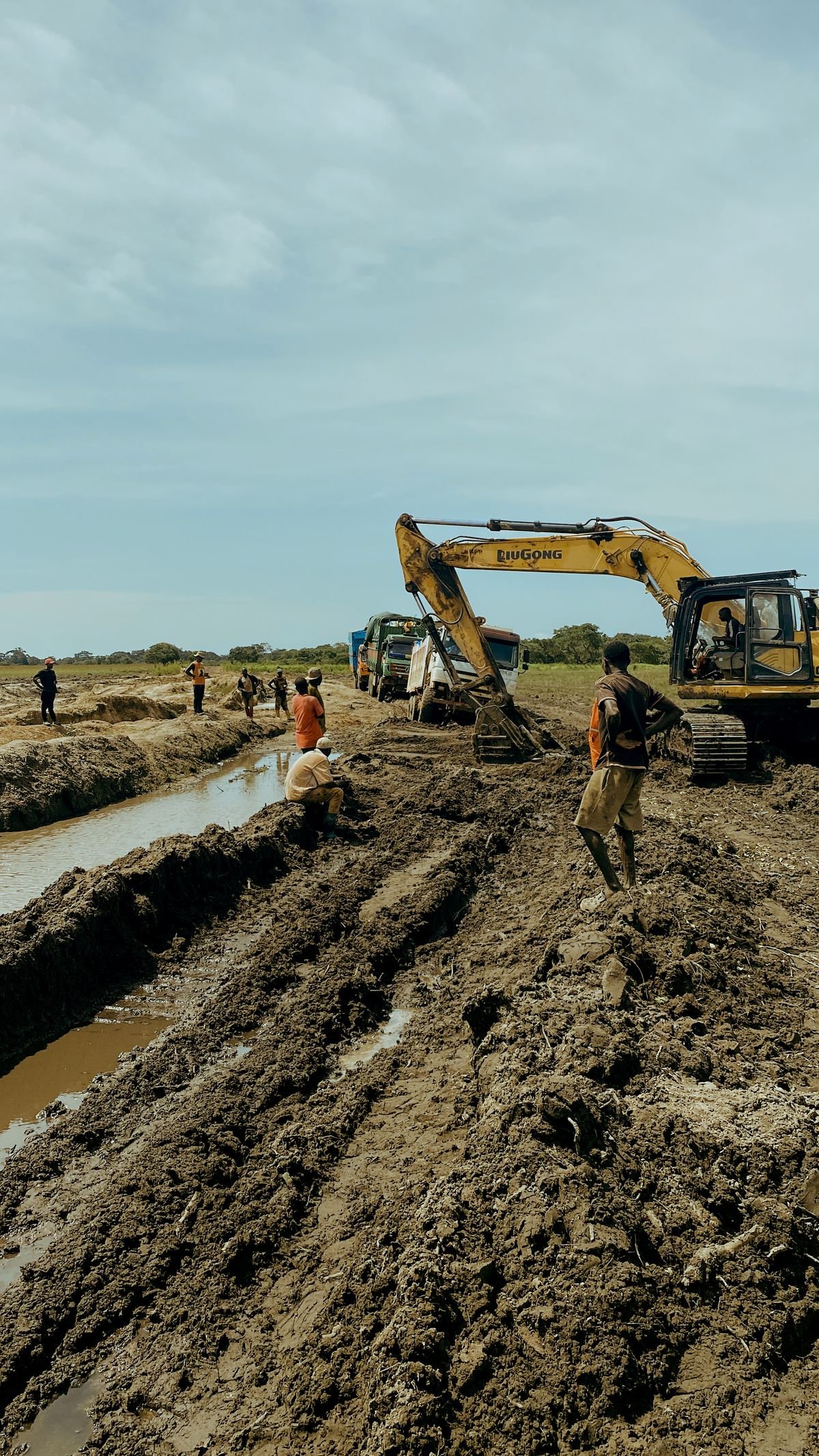 Excavator working along a long open trench for a new sewer line