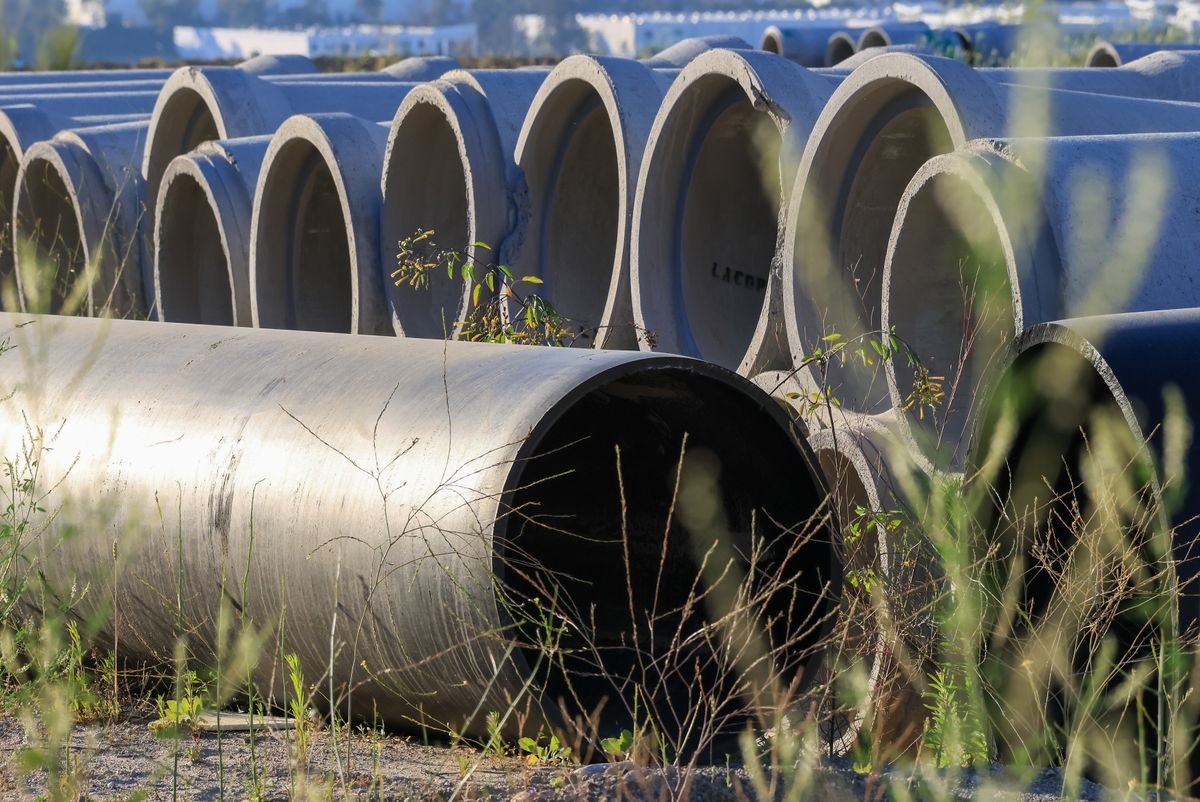 Large-diameter pipe sections stored outdoors before installation